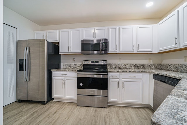 kitchen featuring white cabinetry, light stone counters, and stainless steel appliances