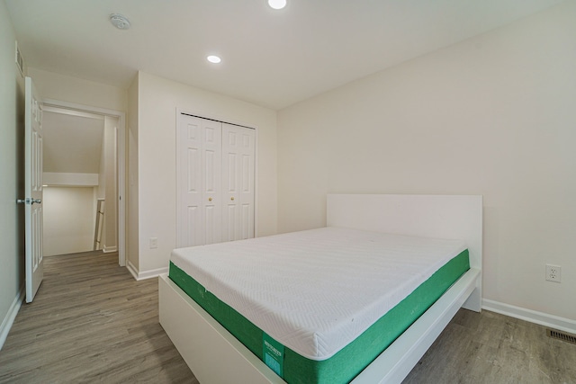 bedroom with hardwood / wood-style floors and a closet