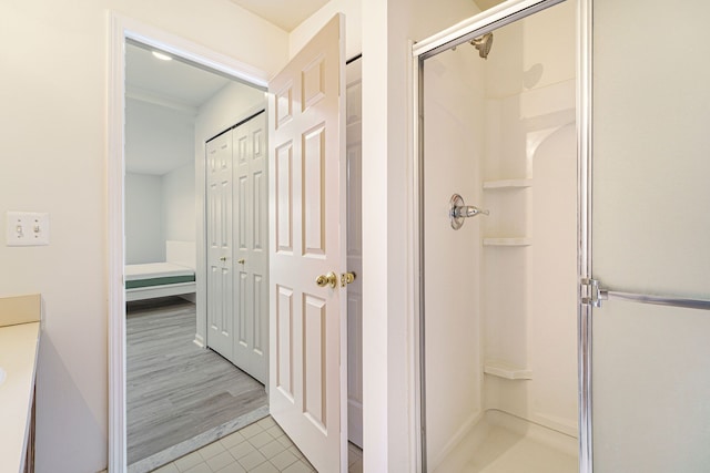 bathroom featuring an enclosed shower and tile patterned flooring