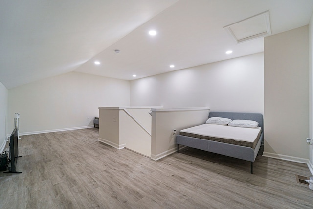 bedroom with lofted ceiling and light wood-type flooring