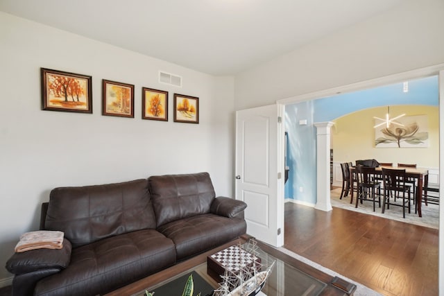 living room with wood-type flooring and ornate columns