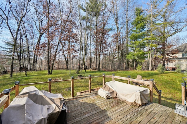 wooden deck featuring grilling area and a lawn