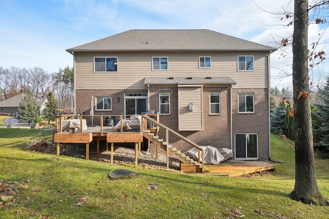 back of house featuring a wooden deck and a lawn