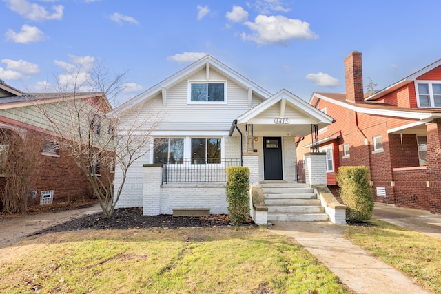 bungalow-style home featuring a porch and a front yard