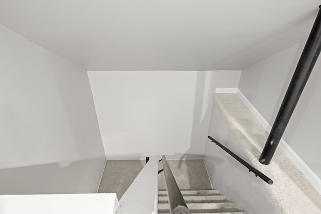 stairway with vaulted ceiling and carpet flooring