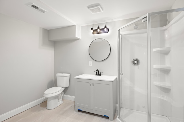 bathroom featuring toilet, vanity, and a shower with shower door