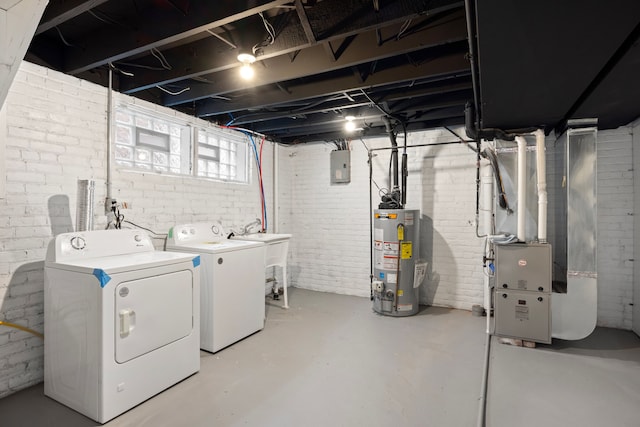 basement featuring gas water heater, washer and dryer, heating unit, sink, and electric panel