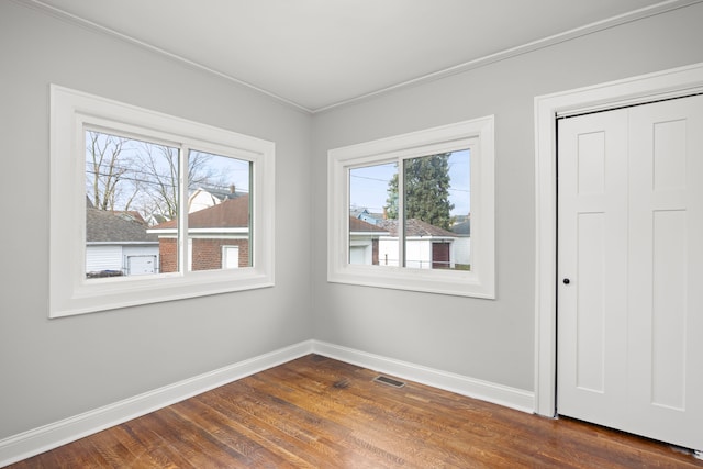 unfurnished room featuring crown molding and dark hardwood / wood-style floors