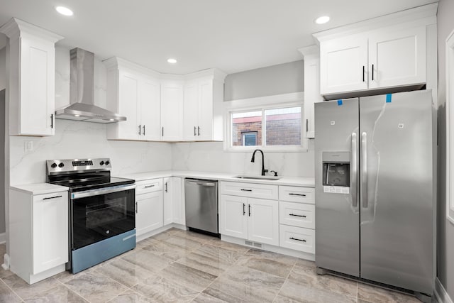 kitchen featuring sink, appliances with stainless steel finishes, tasteful backsplash, white cabinets, and wall chimney exhaust hood