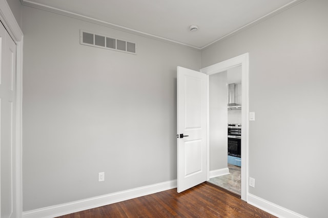 unfurnished room featuring ornamental molding and dark hardwood / wood-style floors