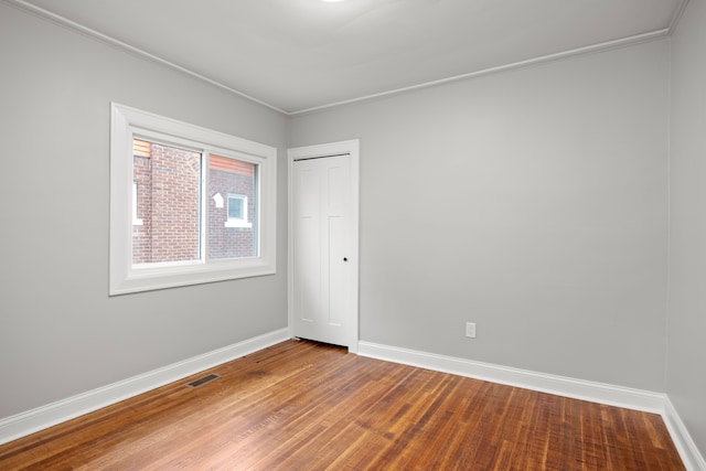 empty room with crown molding and hardwood / wood-style floors