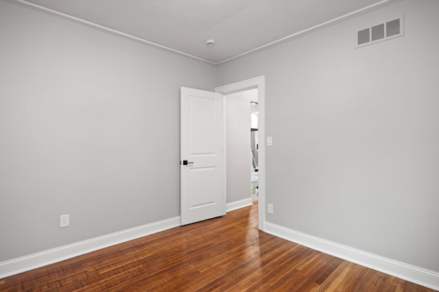 empty room with wood-type flooring and ornamental molding