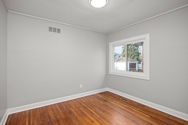 spare room featuring hardwood / wood-style flooring and crown molding