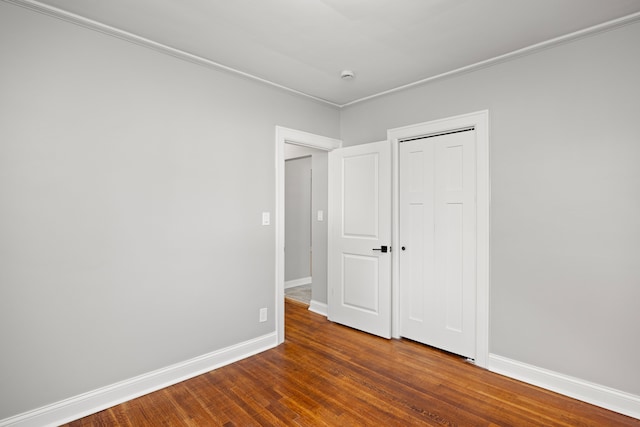 unfurnished bedroom with dark hardwood / wood-style flooring and a closet