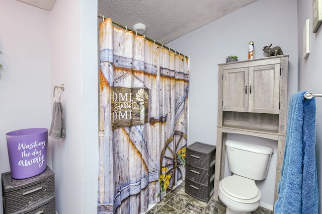 bathroom featuring a textured ceiling and toilet