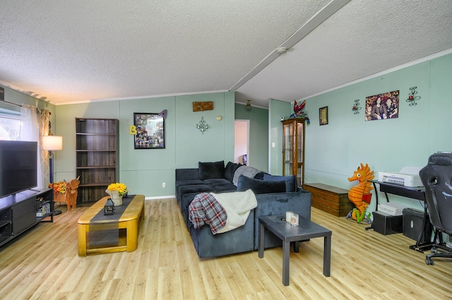 living room featuring a textured ceiling, vaulted ceiling, light hardwood / wood-style flooring, and ornamental molding