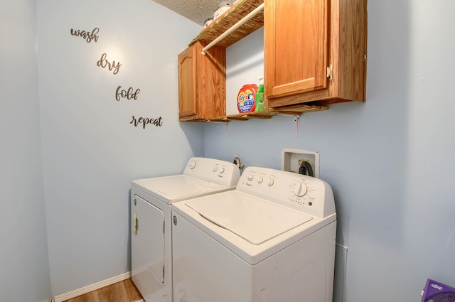 laundry room with separate washer and dryer, cabinets, a textured ceiling, and hardwood / wood-style flooring