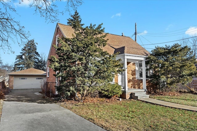 view of front of home with a front lawn, a garage, and an outdoor structure