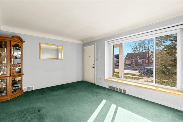 unfurnished room featuring dark carpet and a wealth of natural light