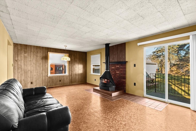 living room with wood walls and a wood stove