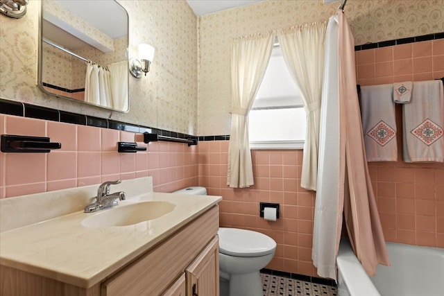 full bathroom featuring tile walls, shower / tub combo with curtain, vanity, and toilet