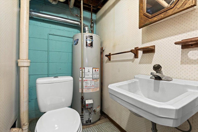 bathroom featuring sink, water heater, and toilet