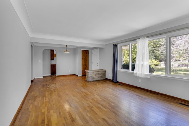 unfurnished living room featuring hardwood / wood-style floors and ornamental molding