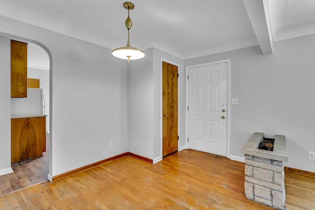 interior space featuring beam ceiling and light hardwood / wood-style flooring