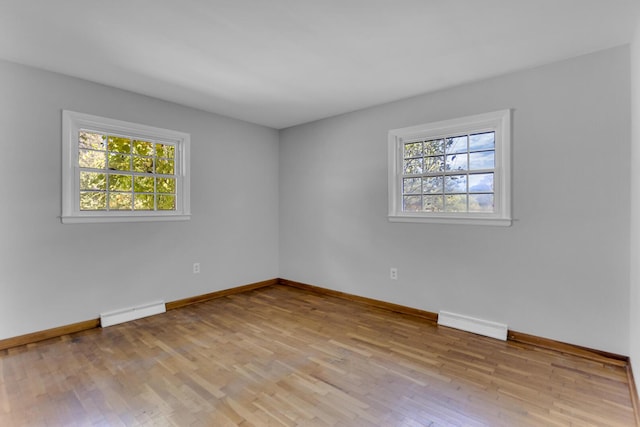 empty room with a baseboard heating unit and light wood-type flooring