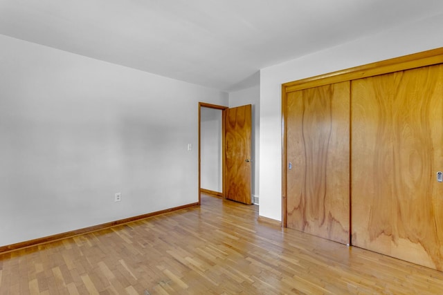 unfurnished bedroom featuring light wood-type flooring and a closet