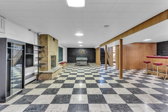 basement featuring bar area and wood walls