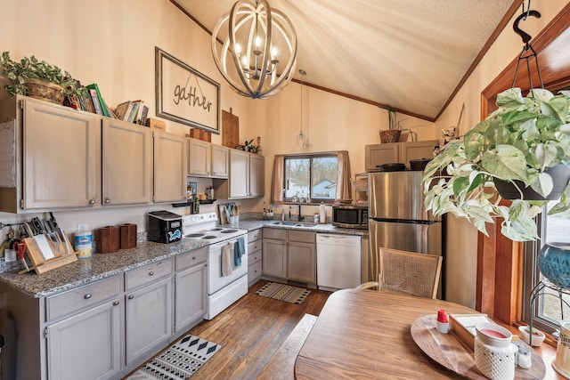 kitchen featuring sink, stainless steel appliances, an inviting chandelier, decorative light fixtures, and lofted ceiling