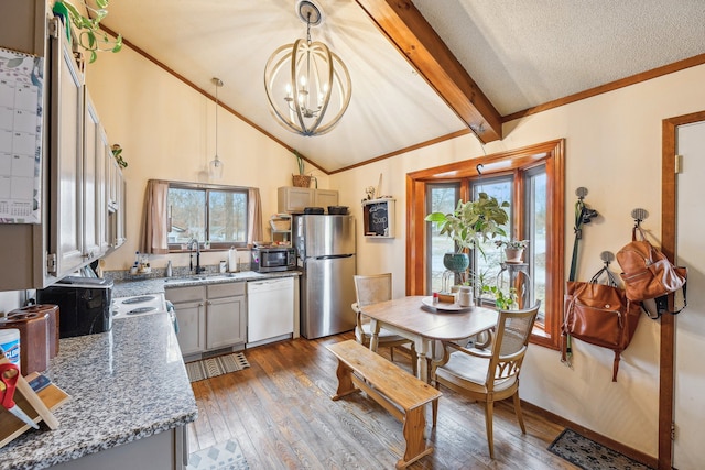 kitchen featuring stone counters, sink, decorative light fixtures, appliances with stainless steel finishes, and hardwood / wood-style flooring