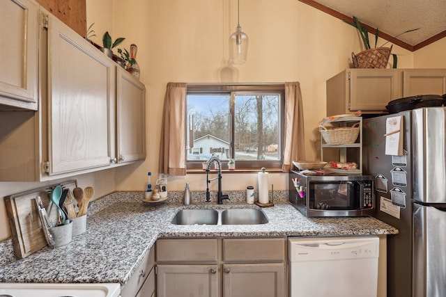 kitchen featuring appliances with stainless steel finishes, light stone counters, sink, pendant lighting, and lofted ceiling