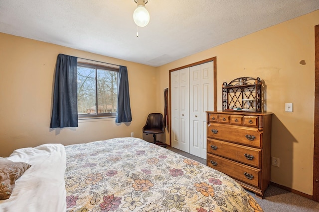 bedroom with carpet, a textured ceiling, and a closet