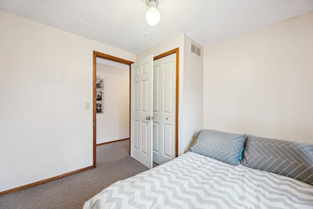 bedroom with a closet and dark colored carpet