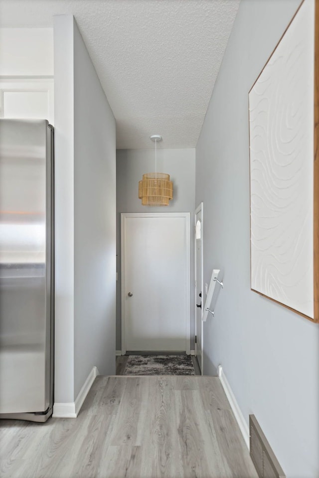 doorway to outside featuring light hardwood / wood-style floors and a textured ceiling