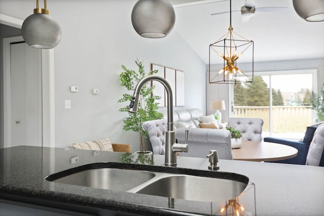 kitchen featuring pendant lighting, a chandelier, sink, and vaulted ceiling