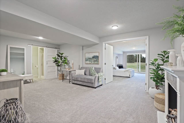 living room with a barn door, light colored carpet, and a textured ceiling