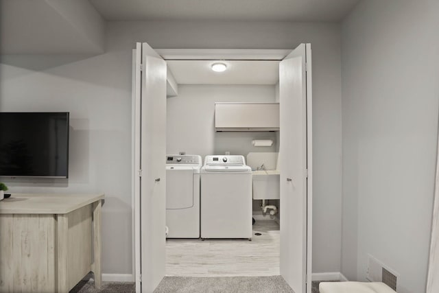 laundry area featuring washing machine and clothes dryer and light colored carpet