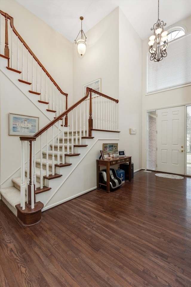 foyer entrance with a high ceiling, dark hardwood / wood-style floors, and a notable chandelier