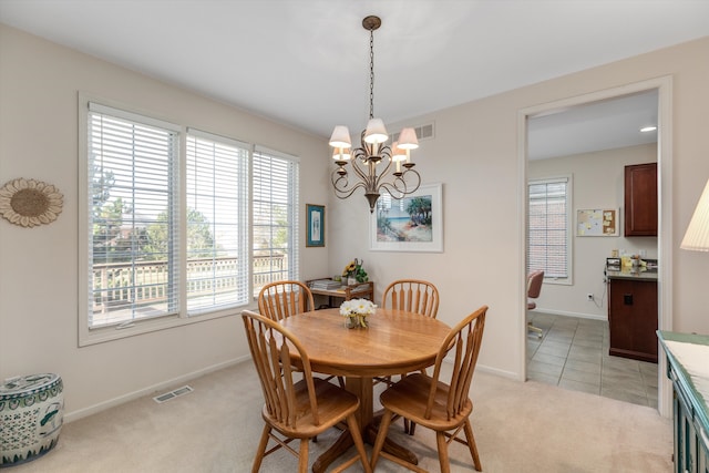 carpeted dining area featuring a notable chandelier and a wealth of natural light