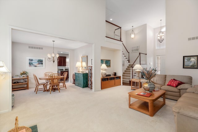 carpeted living room featuring a high ceiling and a notable chandelier