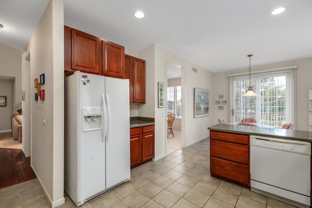 kitchen with white appliances, decorative light fixtures, a notable chandelier, and light tile patterned flooring