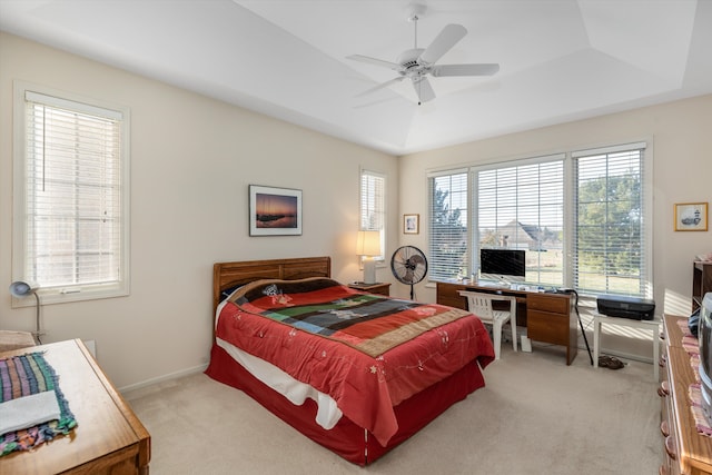 carpeted bedroom featuring a raised ceiling and ceiling fan