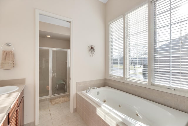 bathroom with tile patterned floors, vanity, and shower with separate bathtub