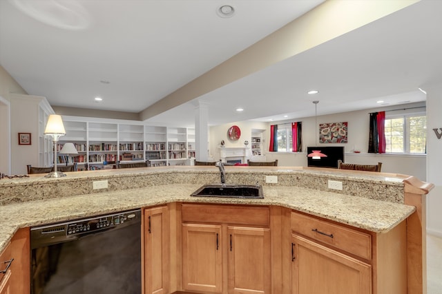 kitchen with light stone countertops, dishwasher, and sink