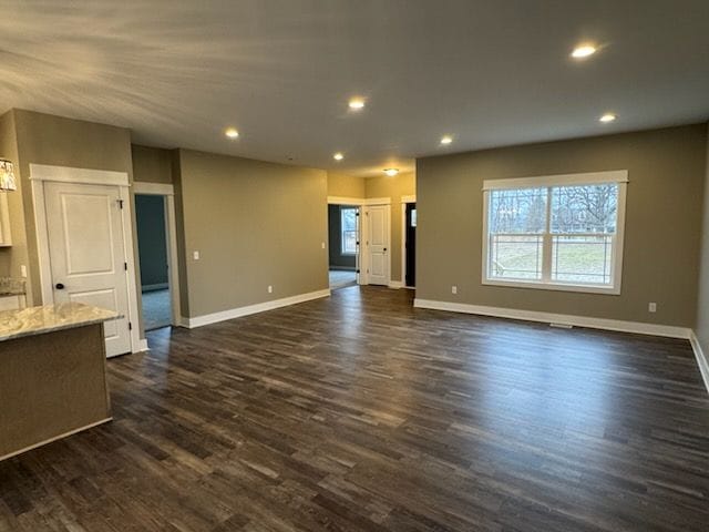 unfurnished living room with dark wood-type flooring