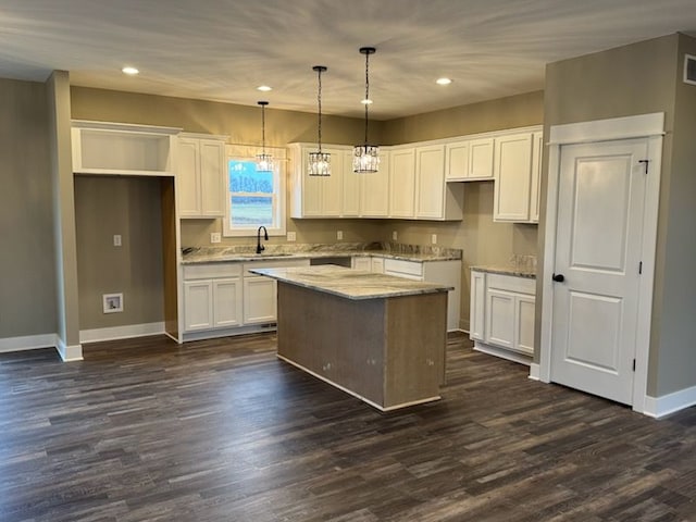 kitchen featuring dark hardwood / wood-style floors, white cabinets, hanging light fixtures, and a center island