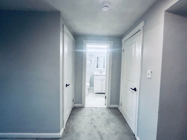 hallway with sink and light carpet